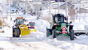 グレーダー車が削った雪を手際よく寄せるショベルドーザ == 株式会社伝書鳩｜経済の伝書鳩｜北見・網走・オホーツクのフリーペーパー ==